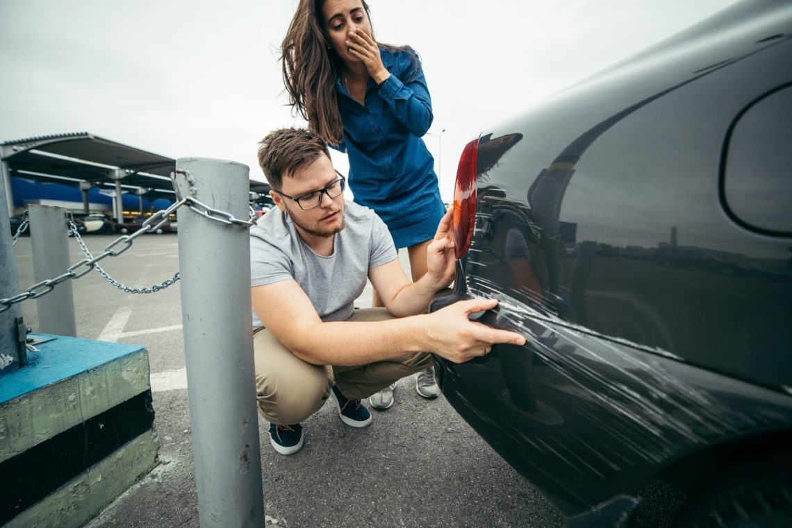 Man and Woman examining a car accident