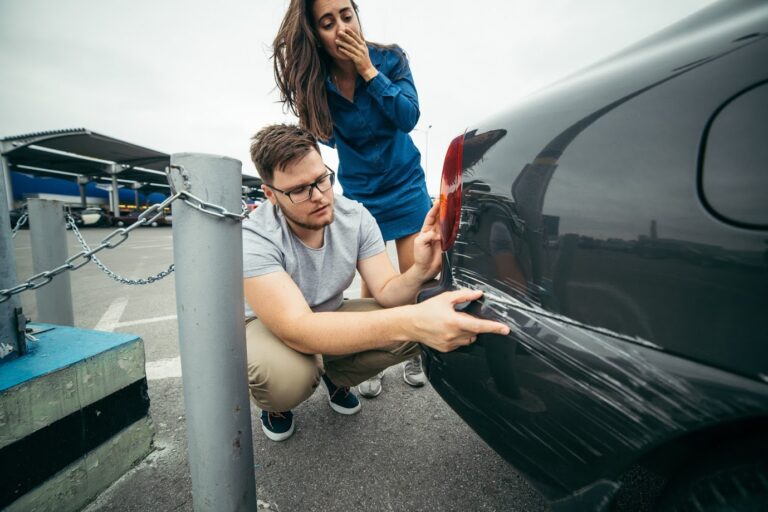 Man and Woman examining scratches on vehicle