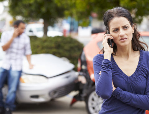 Woman on the phone after a traffic accident