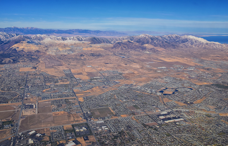 Daybreak Lake and Community and Oquirrh Mountains aerial, Copper Mine, Wasatch Front Rocky Mountains from airplane during fall. South Jordan and Herriman, Utah. United States of America. USA.