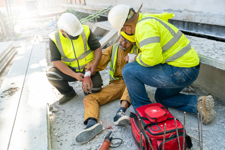 First aid support employee accident in site work, Builder accident injury hand from working, Safety team help employee accident. First aid procedure.
