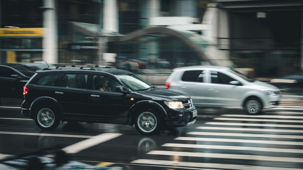 black sedan driving on a slick road