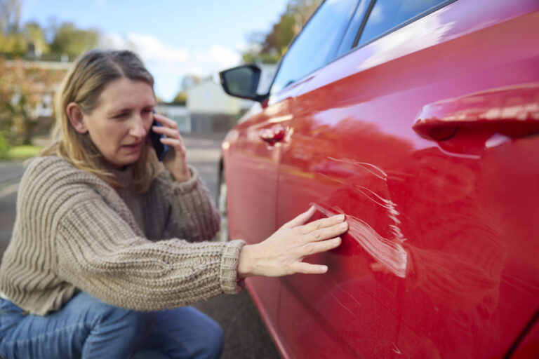 Unhappy Mature Female Driver With Damaged Car After Accident